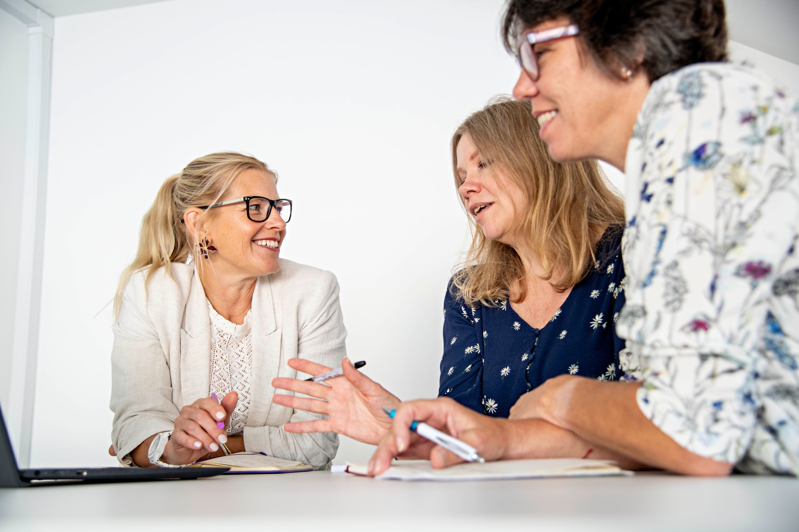 Influence colleagues discussing work together at a desk in the Newark studio